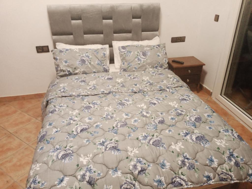 1 cama con edredón y almohadas azules y blancos en Miradore golfe en Martil