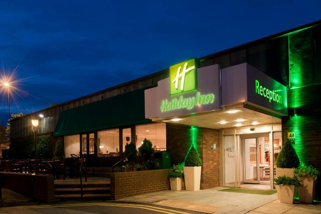 un ristorante con un cartello verde sul lato di un edificio di Holiday Inn Leeds-Wakefield M1 Jct40, an IHG Hotel a Wakefield