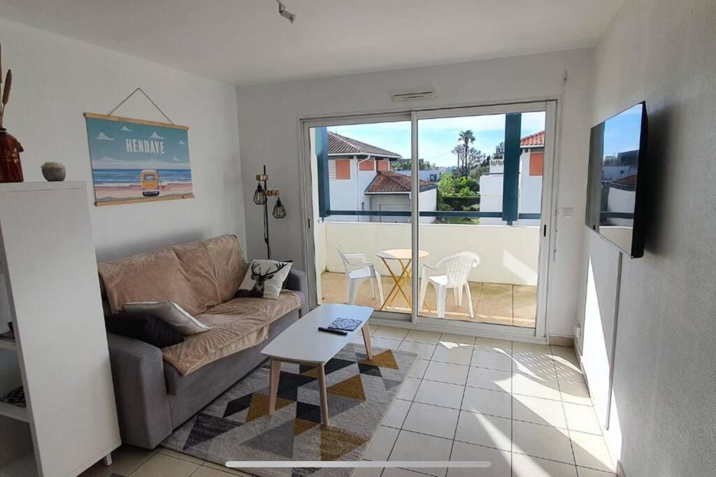 un salon avec un canapé et une table dans l'établissement Le Paisible YourHostHelper, à Bayonne