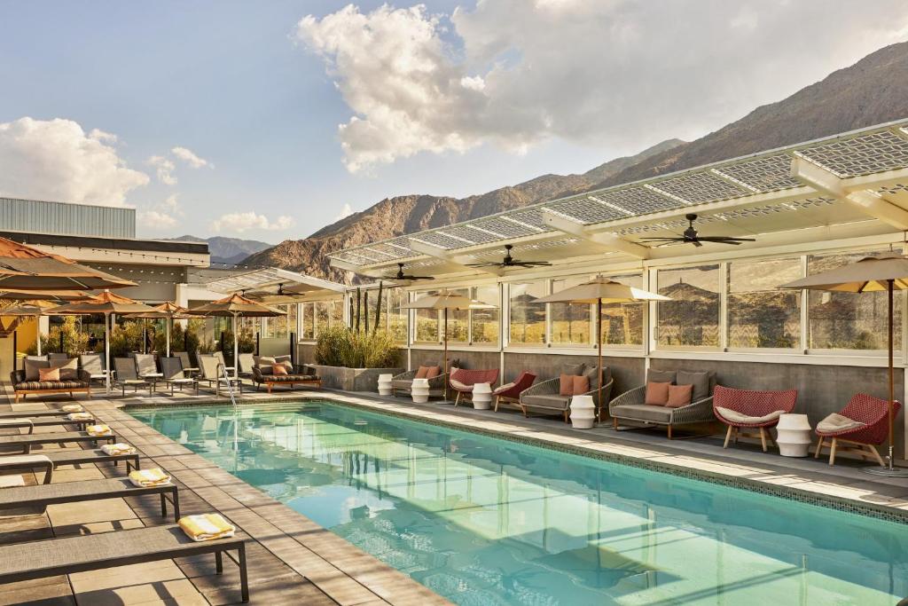 a swimming pool with lounge chairs and a resort at Kimpton Rowan Palm Springs Hotel, an IHG Hotel in Palm Springs
