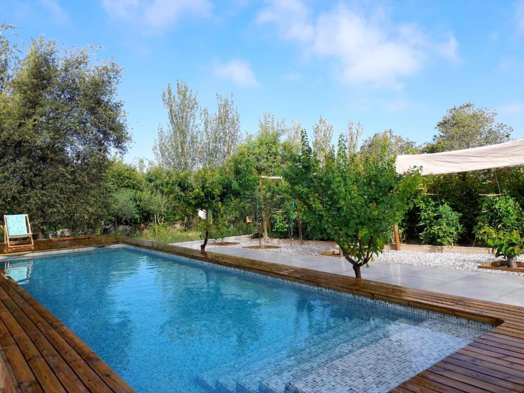 een zwembad in een tuin met een houten terras bij Centro de Agroecologia y Medio Ambiente de Murcia in Bullas