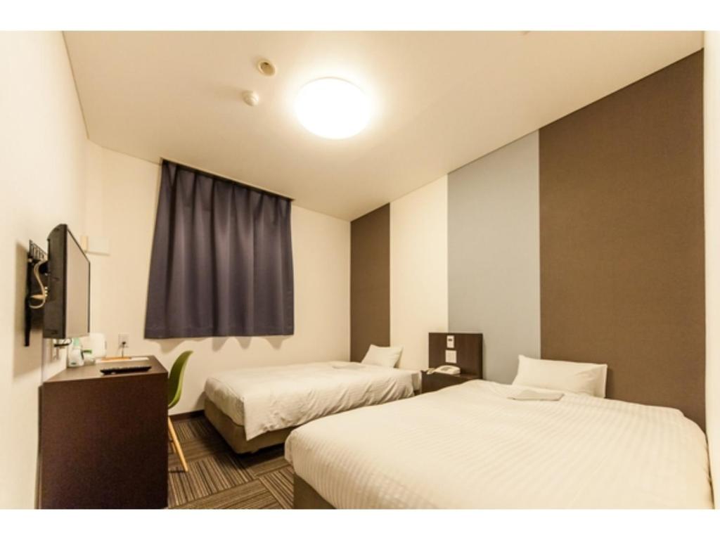 Habitación de hotel con 2 camas y ventana en Mizuho Inn Iwami Masuda - Vacation STAY 17367v, en Masuda