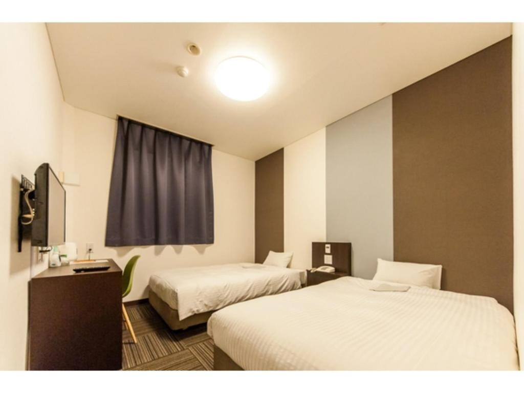 a hotel room with two beds and a window at Mizuho Inn Iwami Masuda - Vacation STAY 17367v in Masuda