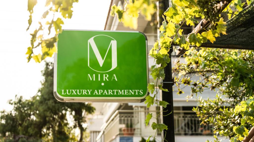a green sign that reads mire luxury apartments at MIRA LUXURY APARTMENTS in Paralia Dionysiou