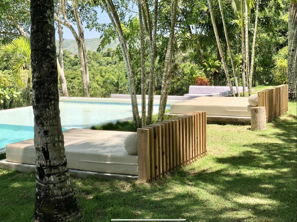 a swimming pool with a bed next to some trees at OYA - Wellness Eco Resort & Retreat - all inclusive in Jamao al Norte