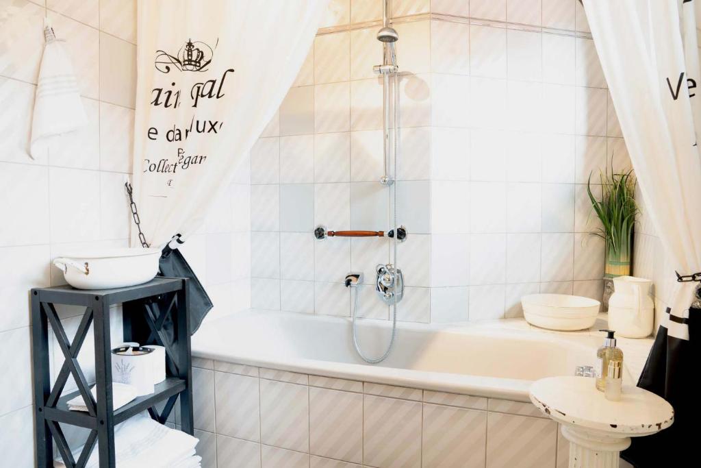 a bathroom with a tub and a toilet and a sink at La belle etage in Coesfeld