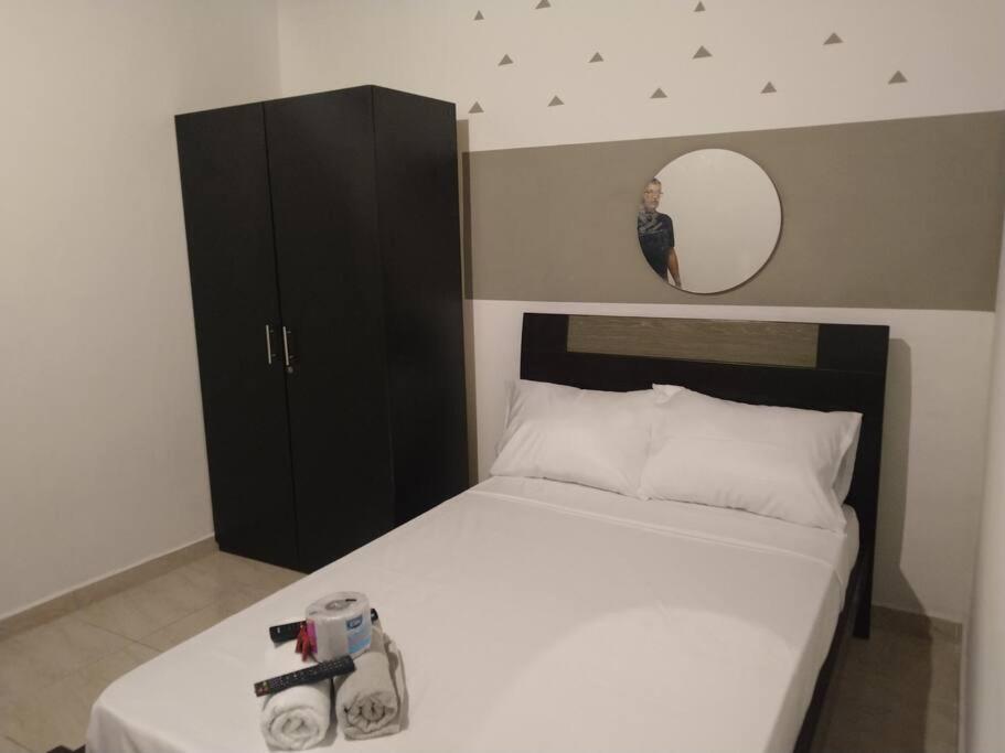 Dormitorio con cama con espejo y cámara en APARTESTUDIO ALCALA ENVIGADO, CERCA A C.C VIVA ., en Envigado