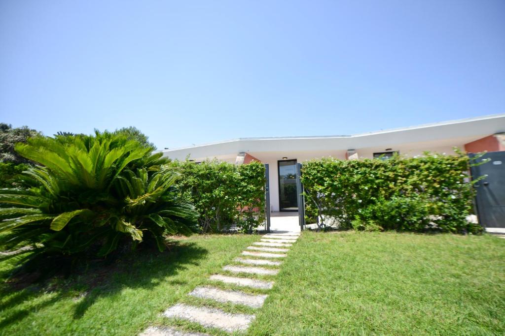a garden with a pathway in front of a building at Grand Hotel Masseria Santa Lucia in Ostuni