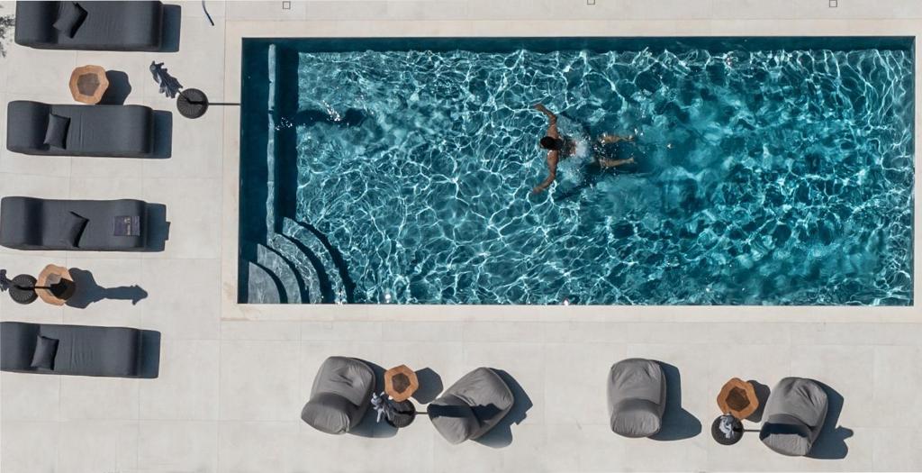 an overhead view of a swimming pool with people in the water at El Mar Naxos in Naxos Chora