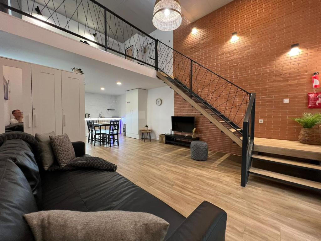 a living room with a couch and a staircase at Grandera Apart`s - Carbonell 1 in Valencia