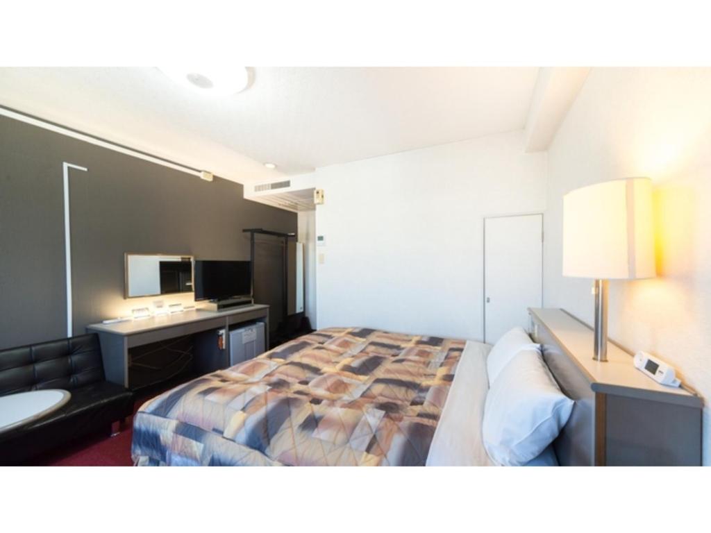 貝塚市にあるSunrise Inn - Vacation STAY 75402vのベッドと机があるホテルの部屋