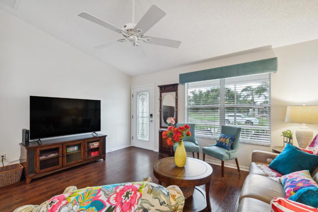a living room with a couch and a tv at Charming Villages Home with Lanai and Golf Cart! in The Villages