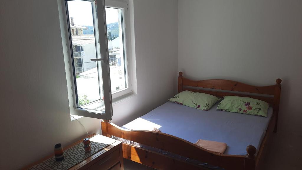 - un petit lit dans une chambre avec fenêtre dans l'établissement Villa Zorka, à Sutomore