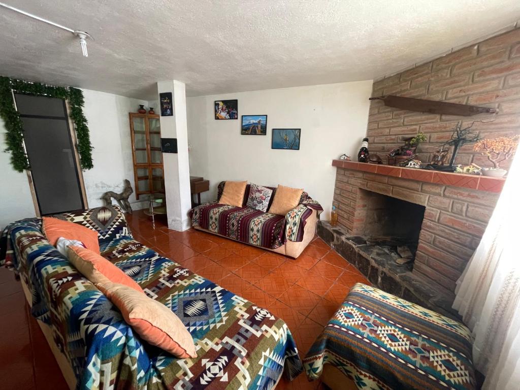 a living room with a couch and a fireplace at Hermoso departamento en el corazón de Papallacta in Papallacta