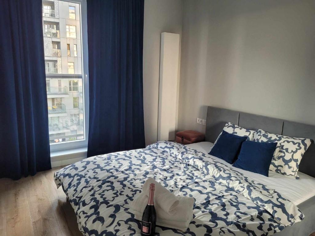1 dormitorio con 1 cama con cortinas azules y ventana en Parkcity Sokolska en Katowice