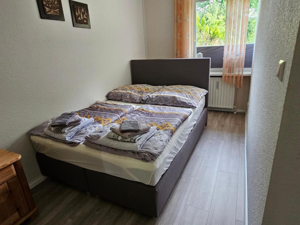 ein kleines Bett in einem Zimmer mit Fenster in der Unterkunft Ferienwohnung 1 Am Park in Divitz
