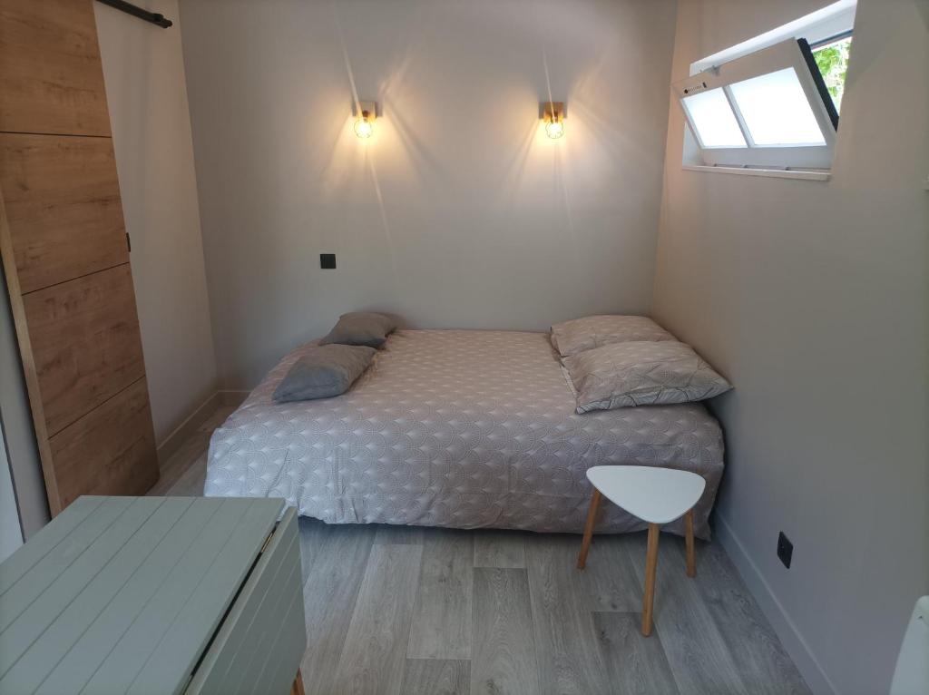 ein kleines Schlafzimmer mit einem Bett und einem Tisch in der Unterkunft Le petit chez-vous in La Rivière Saint Sauveur