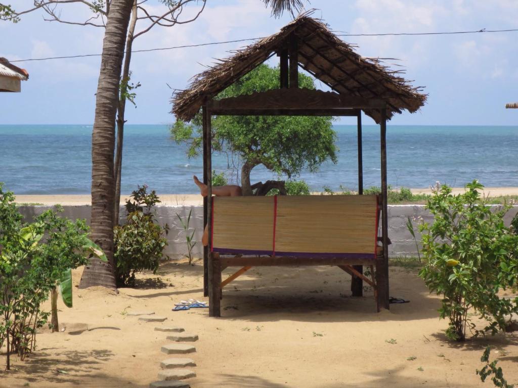 een bankje op het strand met de oceaan op de achtergrond bij Arne's Place in Arugam Bay