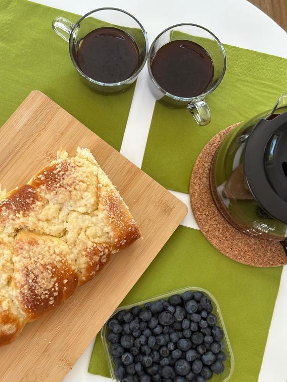 Coffee, blueberries, and pastry on a table with green placemats.