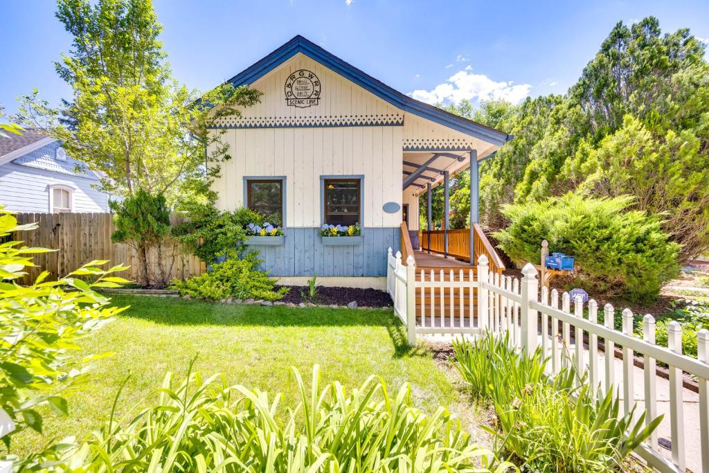a white picket fence in front of a white house at Historic Colorado Springs Home with Yard in Downtown in Colorado Springs