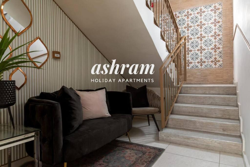 sala de estar con sofá y escalera en By Eezy - דירת סטודיו מסוגננת במיקום מעולה באילת Ashram 5, en Eilat