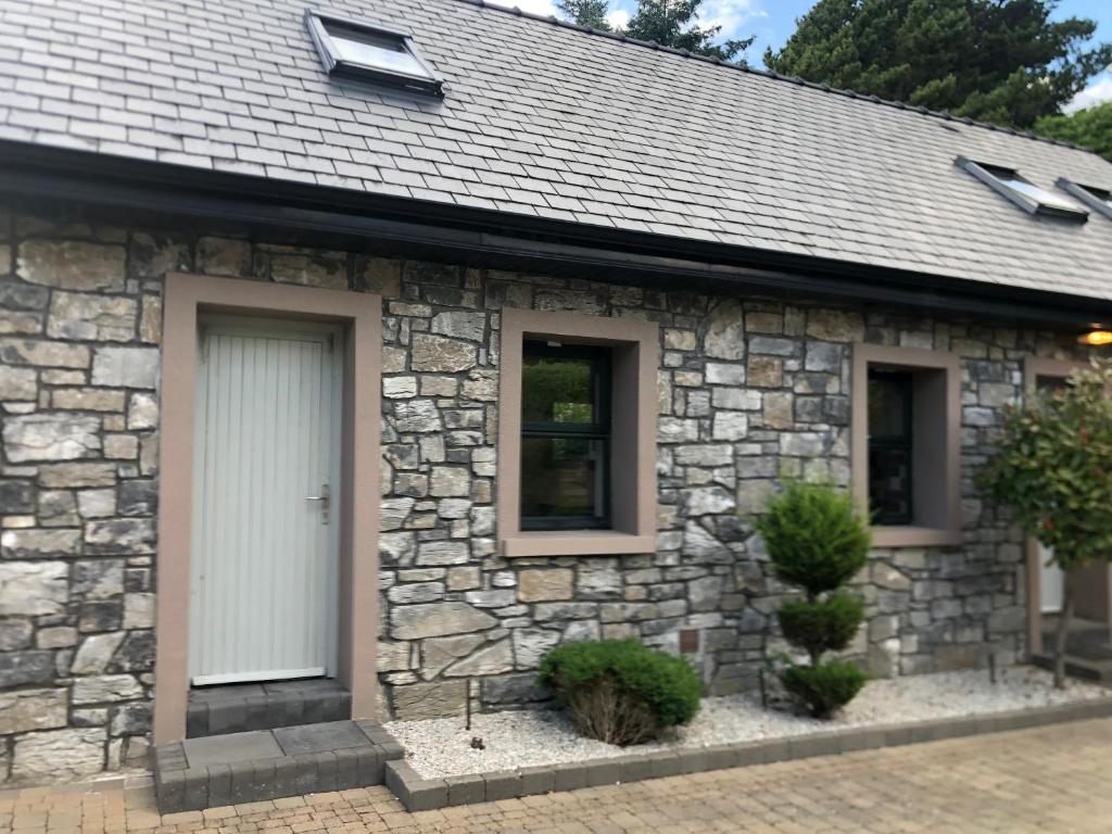 a stone house with a white door and windows at Sióg in Oughterard