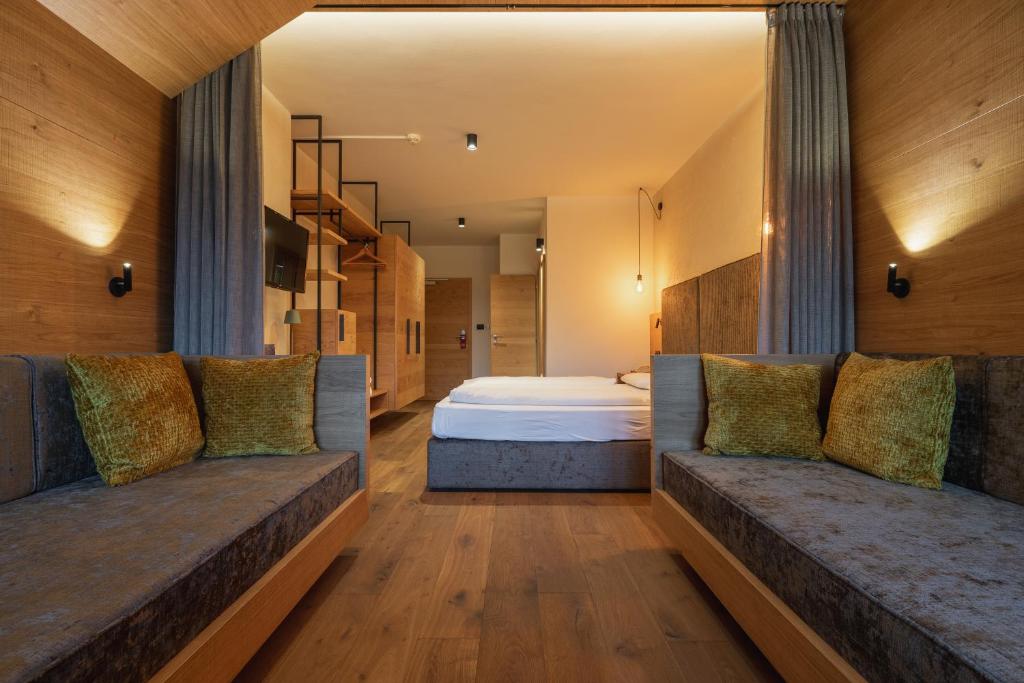 sypialnia z łóżkiem i 2 kanapami w obiekcie Hotel Krondlhof w mieście Brunico