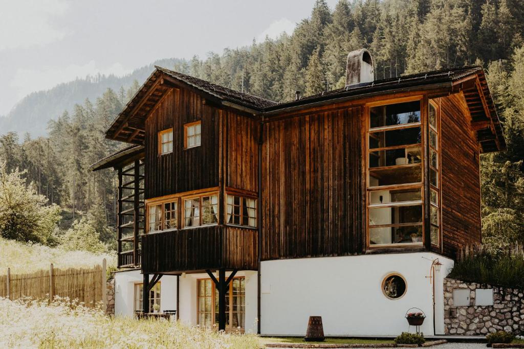 a large wooden house with a white wall at CHALET D'ERT in La Valle