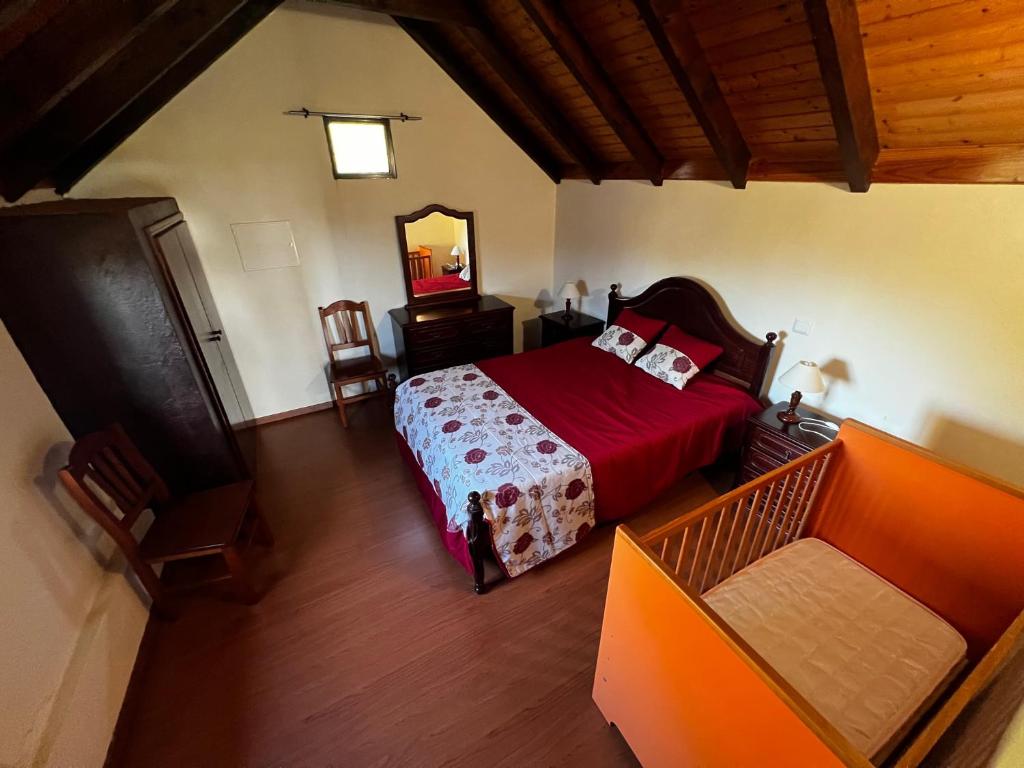 een slaapkamer met een bed en een spiegel bij Quinta da quebrada in Santana