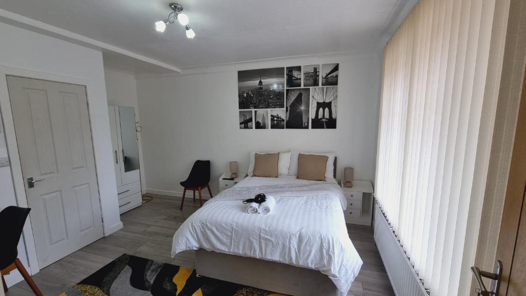 un dormitorio con una cama con un gato sentado en ella en Deluxe Double bedroom with private bathroom, parking and WiFi en Leeds