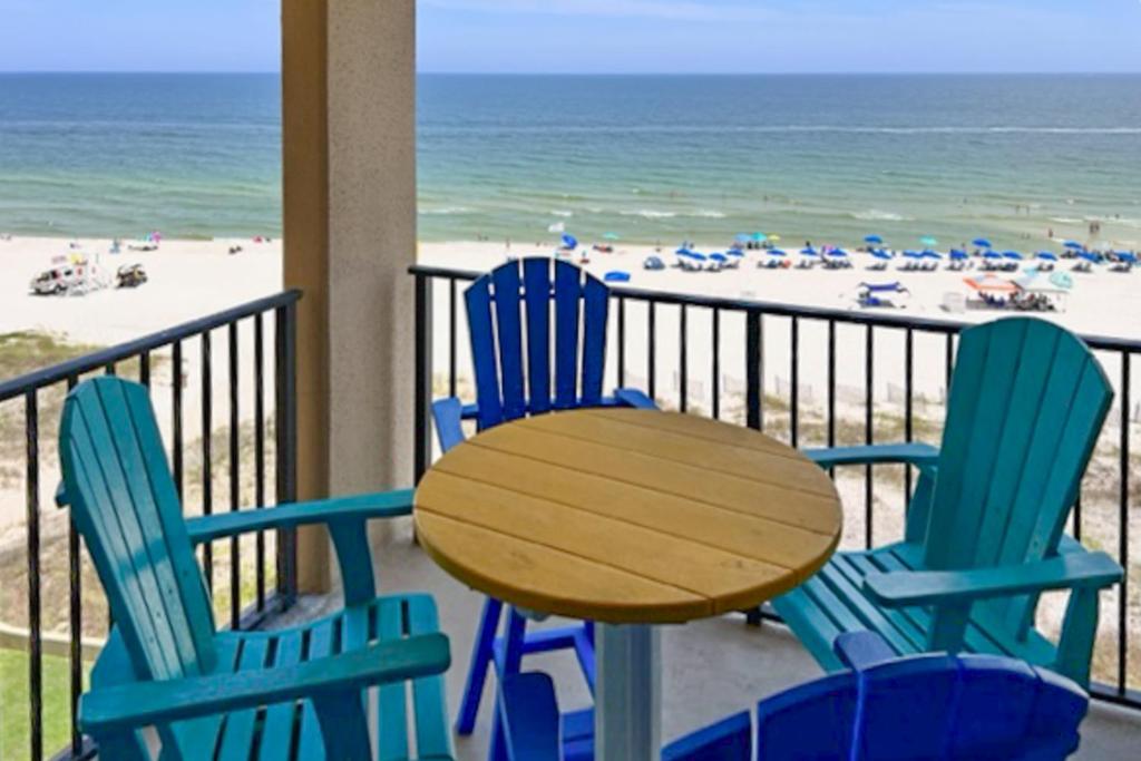 einen Tisch und Stühle auf einem Balkon mit Strandblick in der Unterkunft Phoenix V 614 in Orange Beach