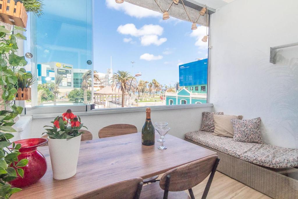 a table with a bottle of wine and a window at ABC - Apartment Beach & City + Balcony 6m2 in Las Palmas de Gran Canaria