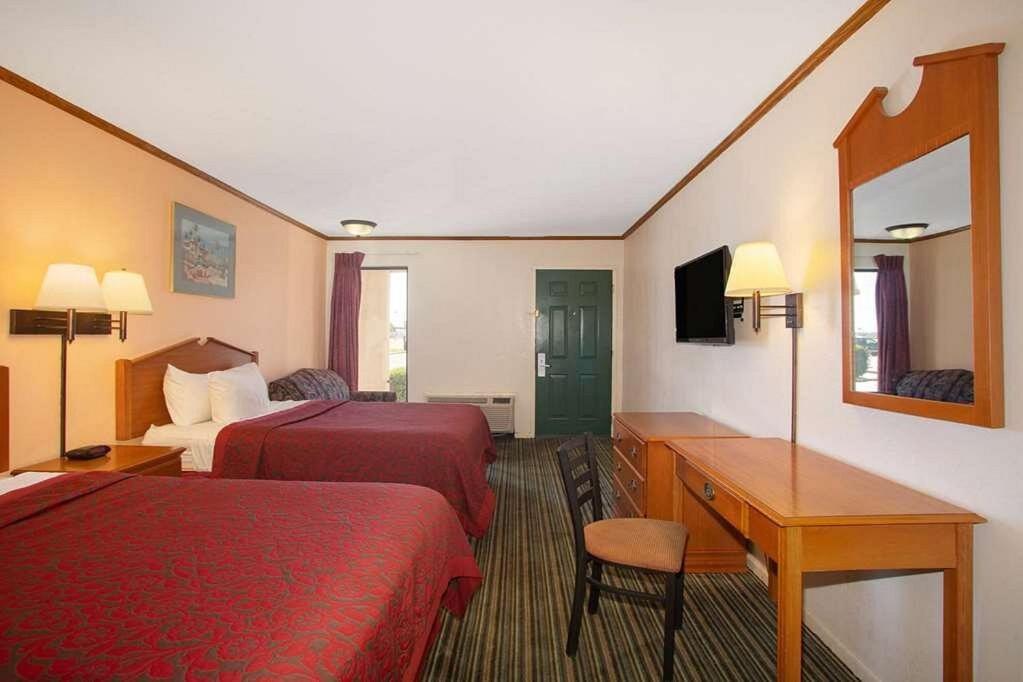 Economy Hotel Wichita 2 في ويتشيتا: غرفة فندقية بسريرين ومكتب