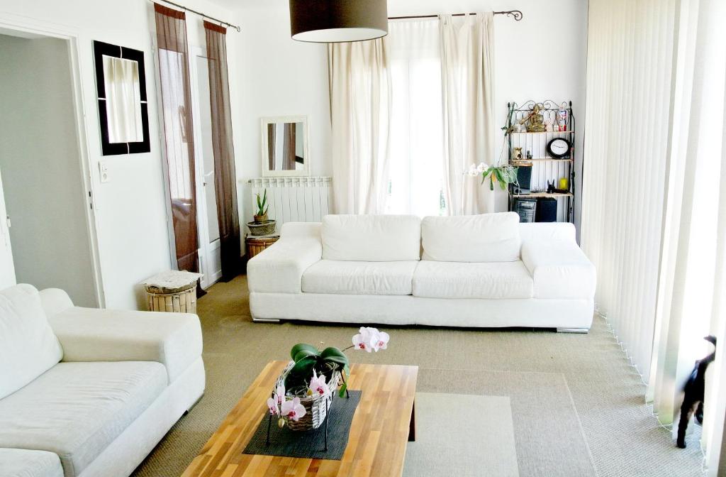 uma sala de estar com um sofá branco e uma mesa de centro em lumière de provence em Mollégès