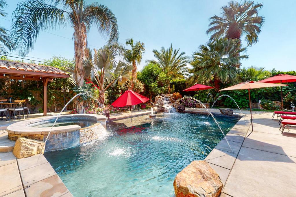 a swimming pool with umbrellas in a resort at Fred Waring Dreams in Palm Desert