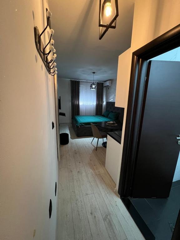 a hallway with a room with a bed and a table at Lux Cotton in Podgorica