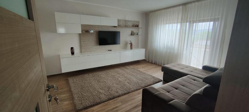 a living room with a couch and a flat screen tv at Apartament 2 camere in Râmnicu Vâlcea