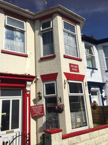 a white and red house with a red door at Holland House in Great Yarmouth