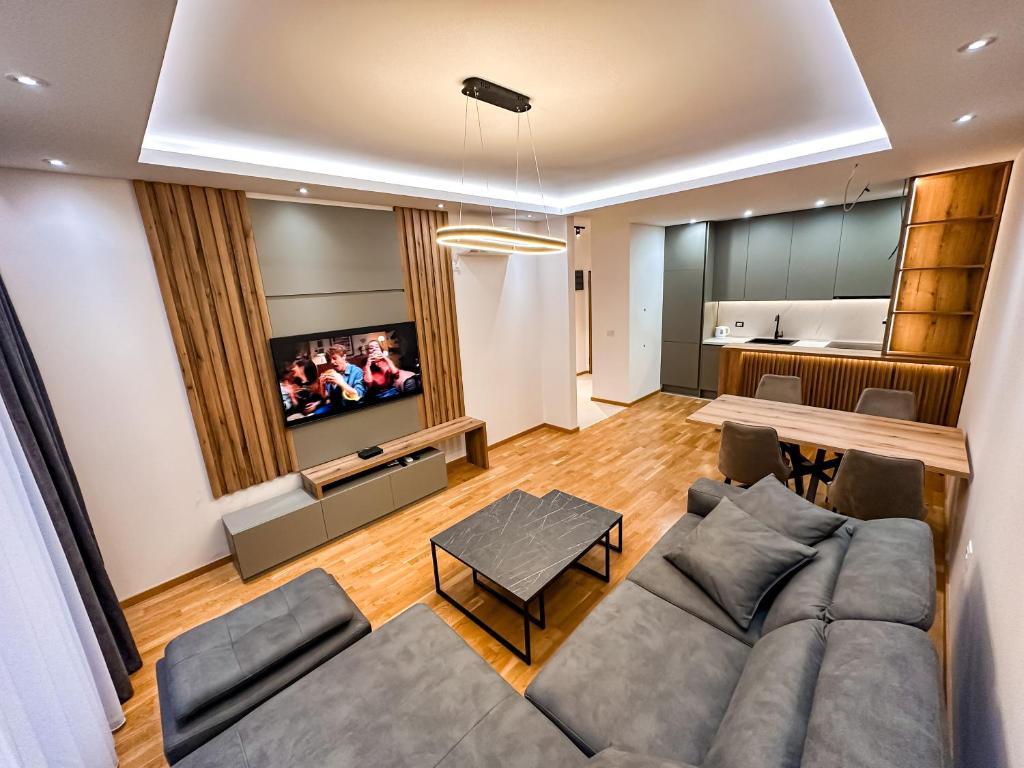 a living room with a couch and a table and a television at Enigma Apartment in Ulcinj