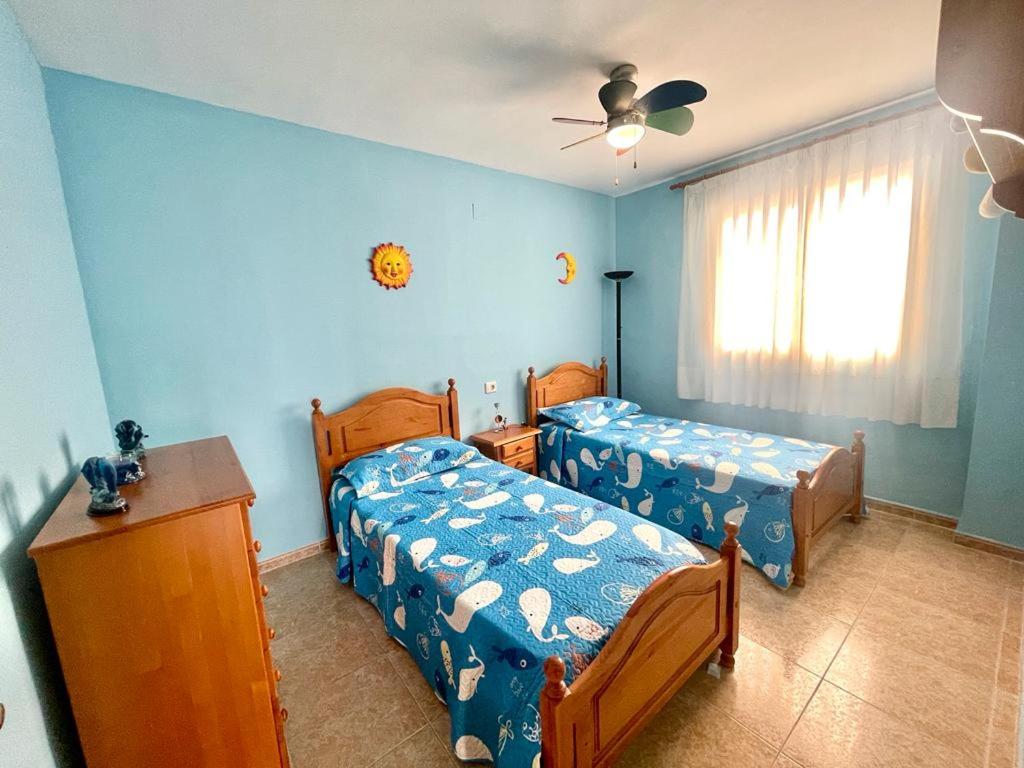 een slaapkamer met 2 bedden en een plafondventilator bij Apartamento al lado de la playa in Moncófar