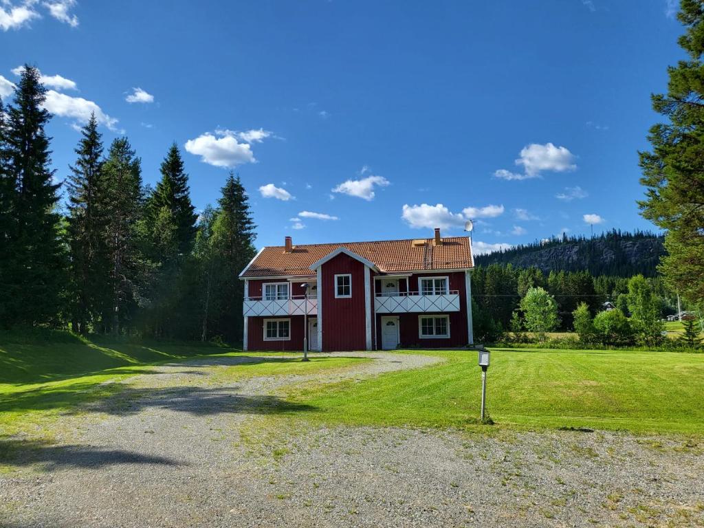 una casa roja en una colina con un patio en Stugby Marieke - Skärvången en Föllinge