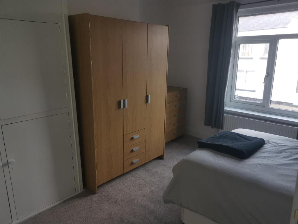 a bedroom with a large wooden cabinet and a bed at John Street in Shildon