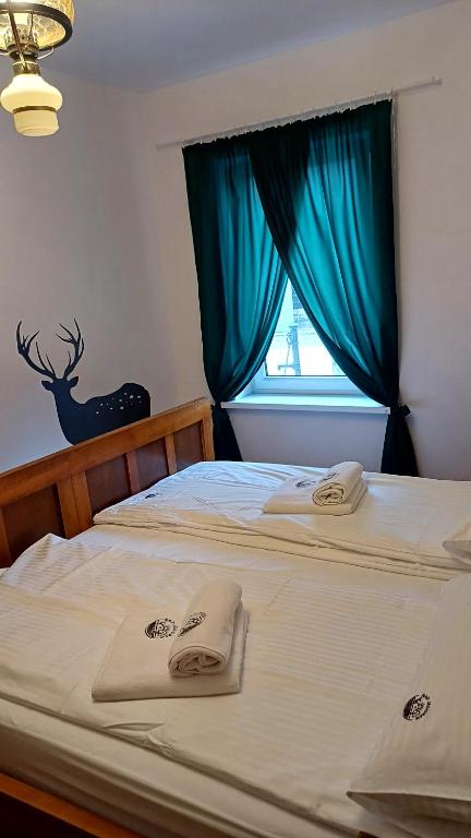 a bedroom with two beds with towels on them at NAD JEZIOREM - Apartamenty in Brenno