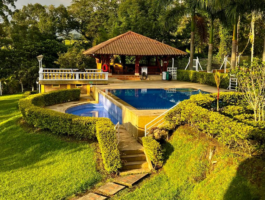 a swimming pool in a yard with a gazebo at Hotel Casa Confort in Santa Rosa de Cabal