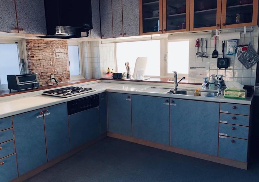 een keuken met blauwe kasten en een wastafel bij Kamome Building 3F - Vacation STAY 50177v in Otaru