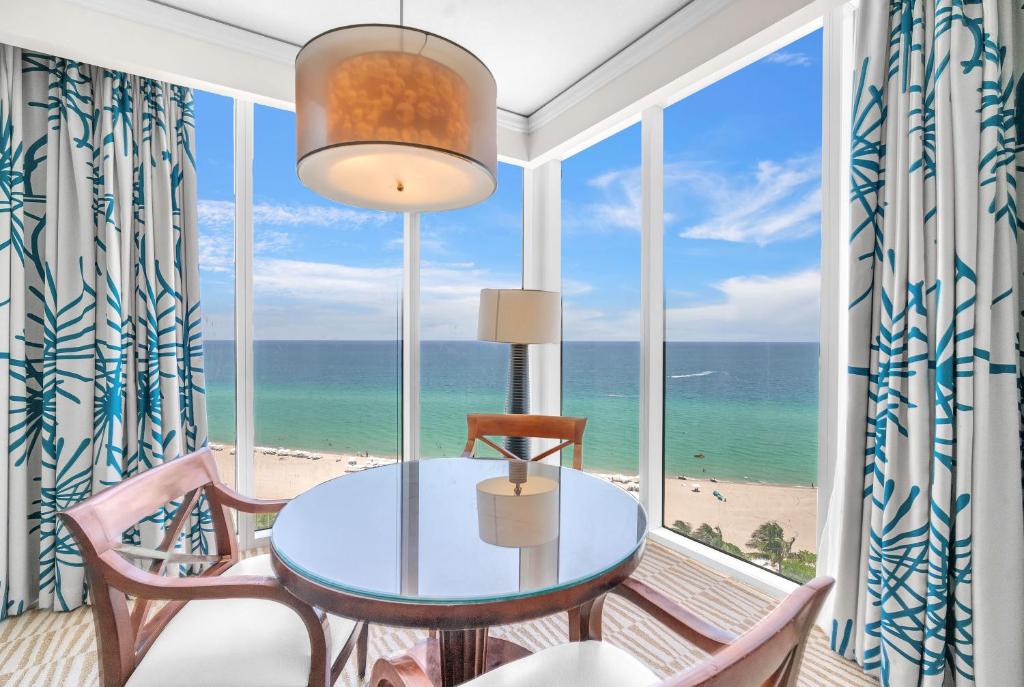 a dining room with a view of the beach at TRUMP INTL 2 BEDROOM APARTMENT 1600 Sqf OCEAN FRONT in Miami Beach