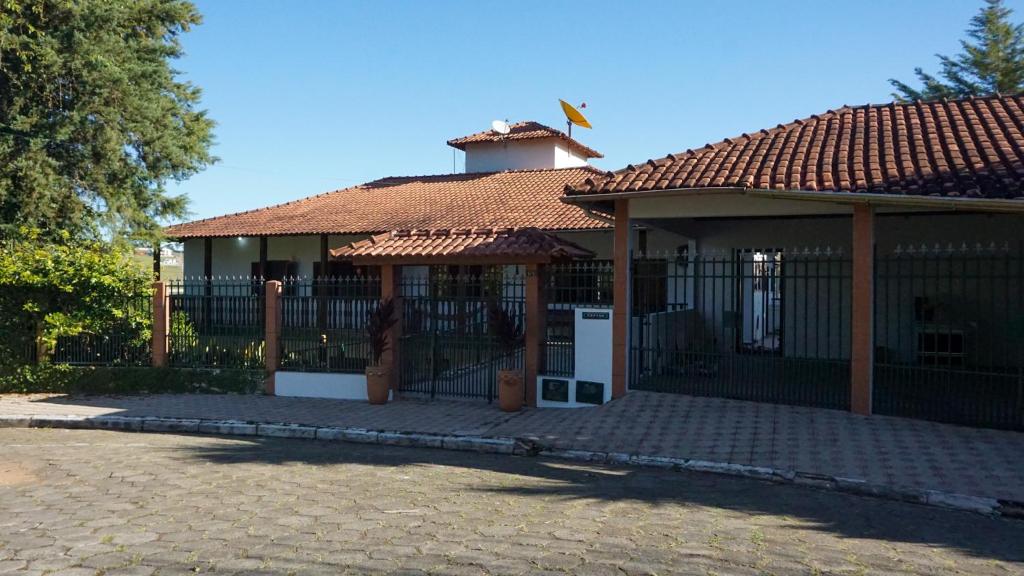 a small house with a gate and a fence at Pousada dos Ventos São Lourenço in São Lourenço