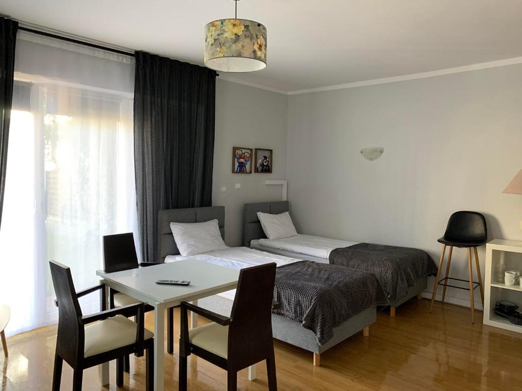 1 dormitorio con 1 cama, mesa y sillas en Dom na Północy en Władysławowo