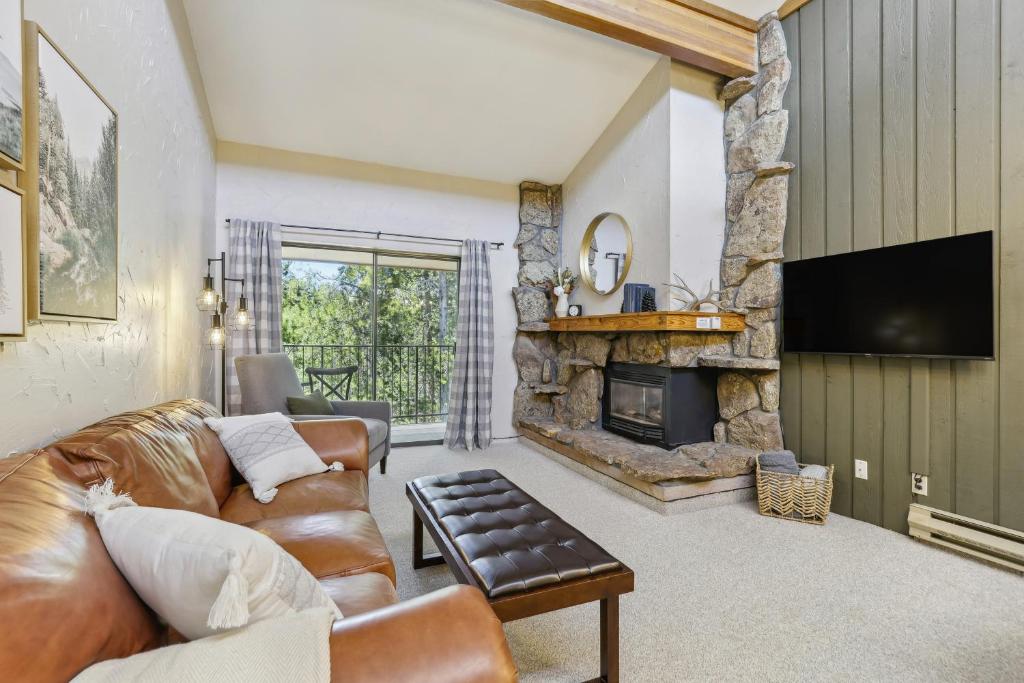 a living room with a couch and a fireplace at Cozy Winter Park Condo Bike, Ski, and Hike! in Winter Park