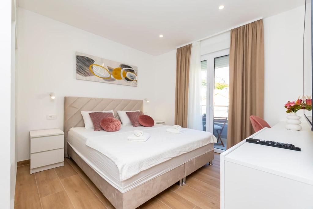 ein weißes Schlafzimmer mit einem Bett und einem Schreibtisch in der Unterkunft New Apartment White Angel in Duće